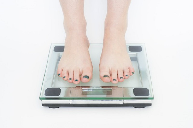 woman on weight scales with black toe nail polish