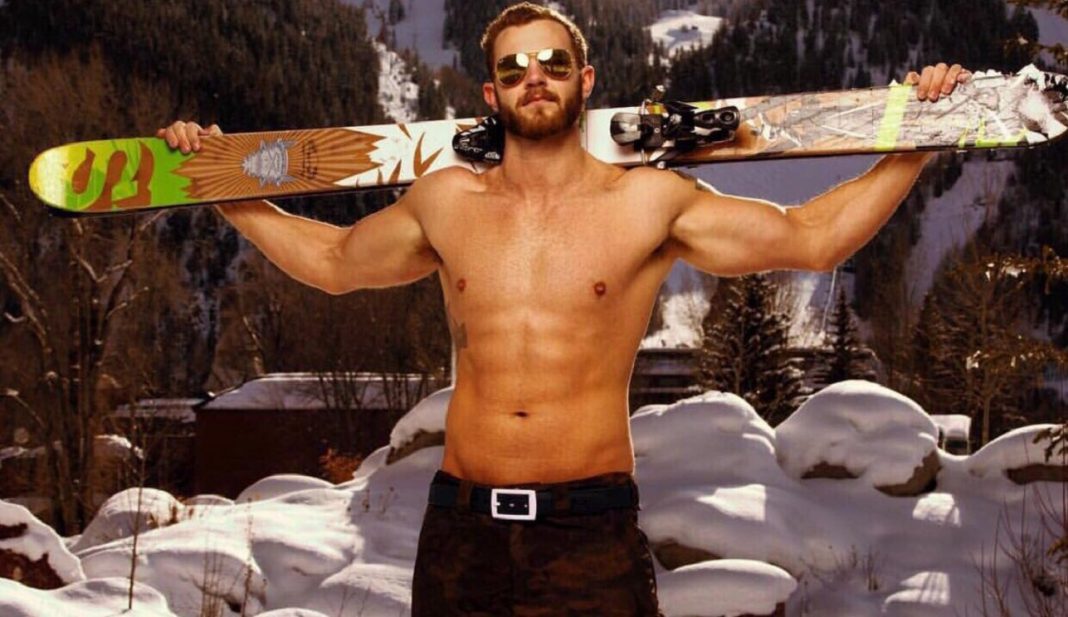 shirtless guy with sunglasses and skis over shoulder outside in winter