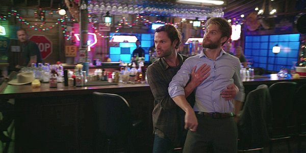 Walker holding back a drunk Liam at bar.