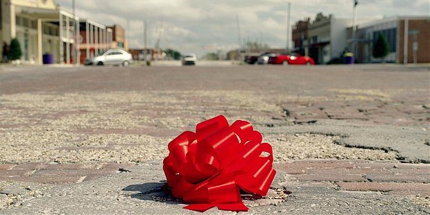 Red wrapping ribbon sits alone and aloof on the streets of Austin for Walker.