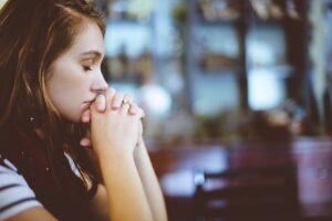 woman sitting with eyes closed in bar grieving