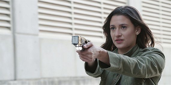 Walker Ashley Reyes holding stun taser gun on Jared Padalecki on set.