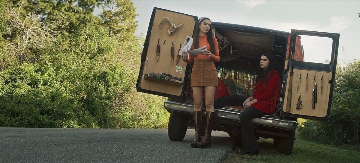 Wide shot of Lata and gay Carlos at back of van with lots of demon hunting tools on The Winchesters.