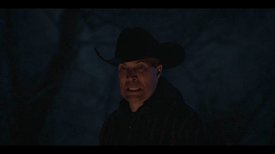 Cody Bell in cowboy hat fireside chat on Walker set.
