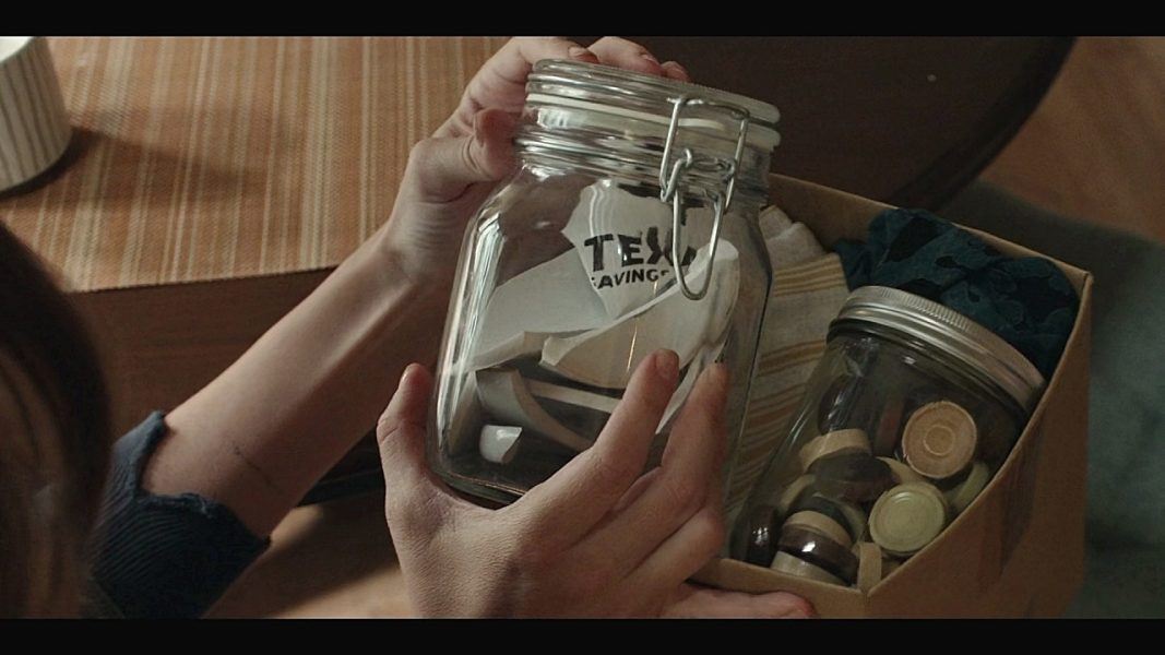 Walker Cassie holding glass jars of stuff she saved over the years.