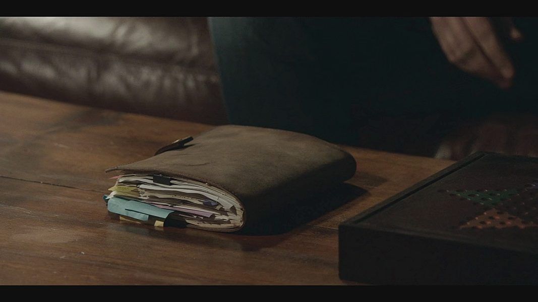 James sets a Supernatural style journal on the table.